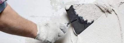 Person trägt mit Kelle Putz auf